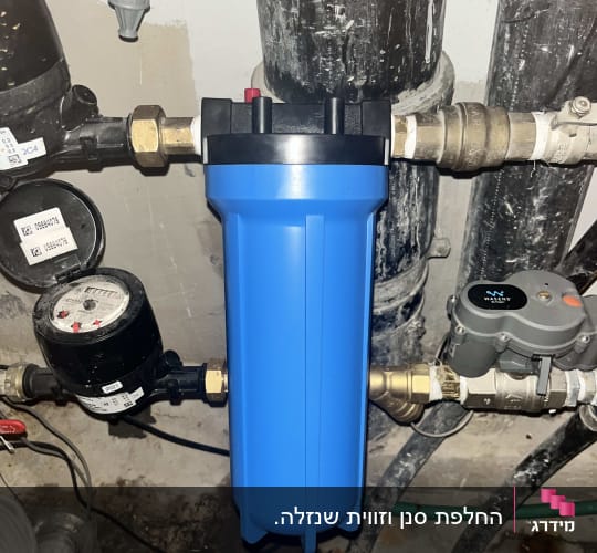 מסנן מים כחול וצינורות במערכת אינסטלציה